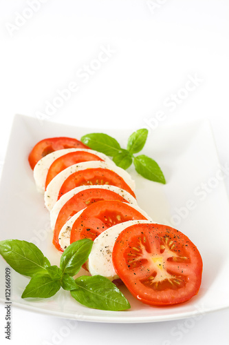 Caprese salad with mozzarella cheese, tomatoes and basil isolated on white background

