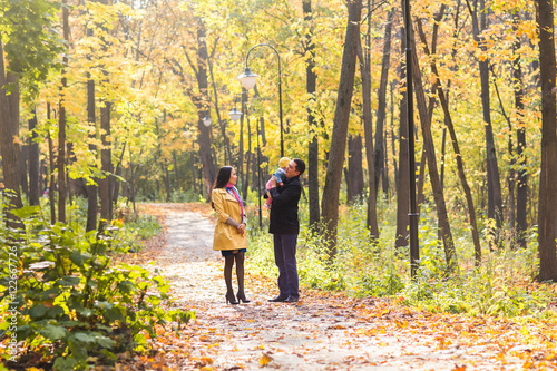 love, parenthood, family, season and people concept - smiling couple with baby in autumn park © satura_
