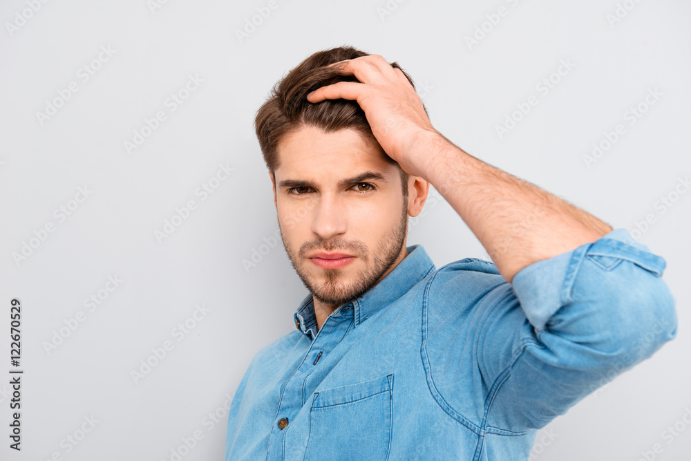 Portrait of handsome young guy combing his hair with fingers Portrait of handsome young guy combing his hair with fingers