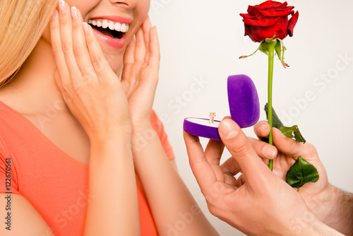 Obraz na plátně Close up of happy excited girl. Her boyfriend making proposal of