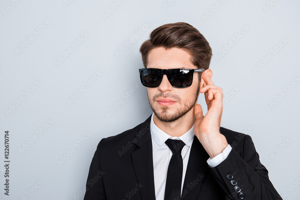 Portrait of handsome young security guard in black glasses