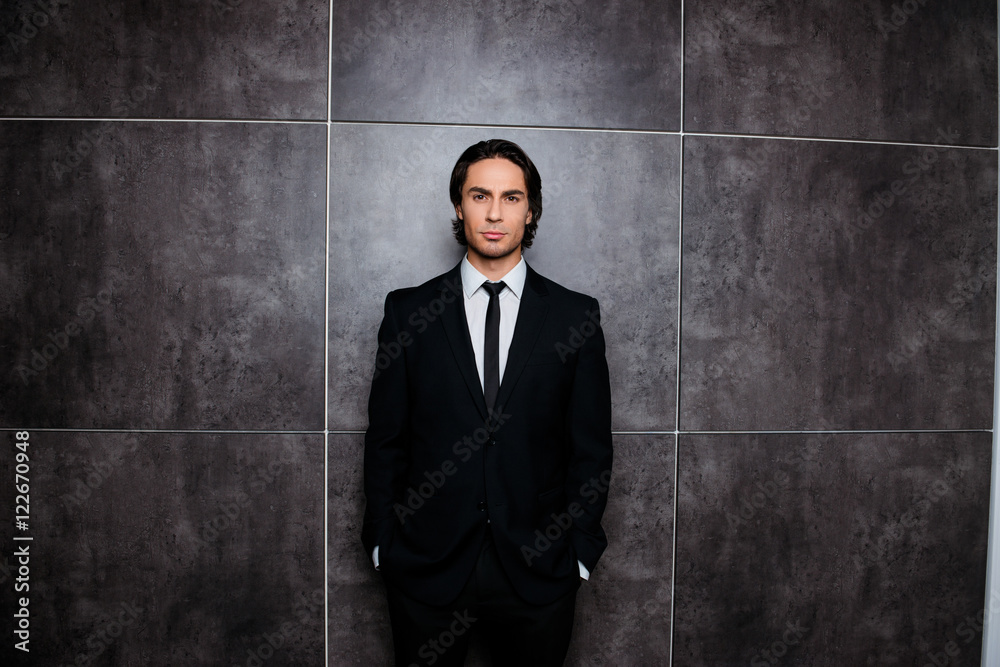 Handsome rich businessman in black tuxedo on gray background Handsome rich businessman in black tuxedo on gray background