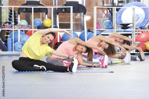 Group of beautiful young women working out at the gym
