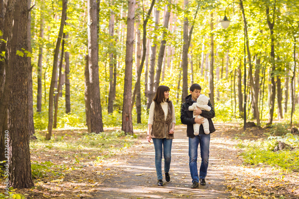 love, parenthood, family, season and people concept - smiling couple with baby in autumn park