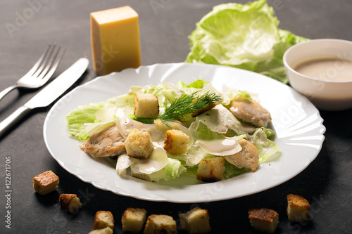 Classical Caesar salad with sliced chicken meat, cheese and fresh salad
