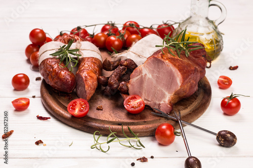Antipasto catering platter with salami and meat on a wooden background