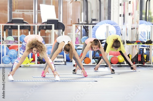 Group of beautiful young women working out at the gym