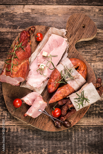 Antipasto catering platter with salami and meat on a wooden background photo