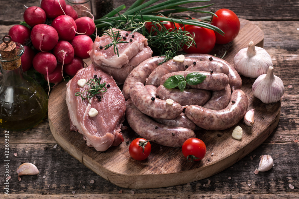 Fresh butcher cut meat assortment garnished with fresh rosemary on wooden table Fresh butcher cut meat assortment garnished with fresh rosemary on wooden table
