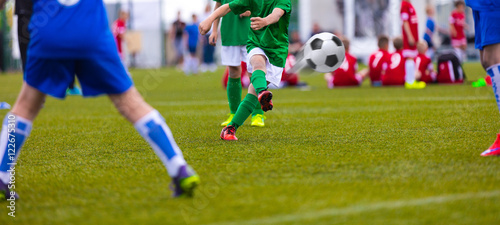 Football kick. Soccer ball in motion. Young soccer player kicking soccer game on sports field