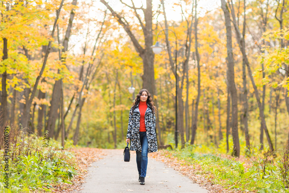 Autumn concept - Beautiful young modern woman walking in nature