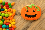 Smiling pumpkin cookie with many colorful candies
