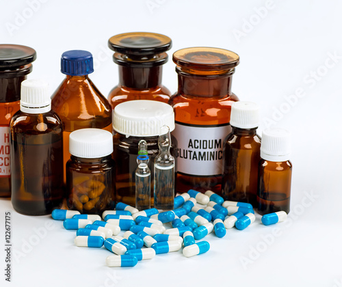 Various cold prescription bottles and a syringe isolated on a wh