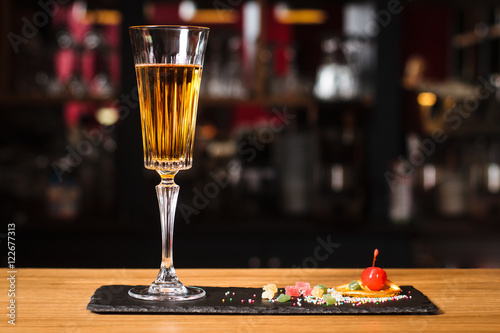 Glass of cocktail on bar background
