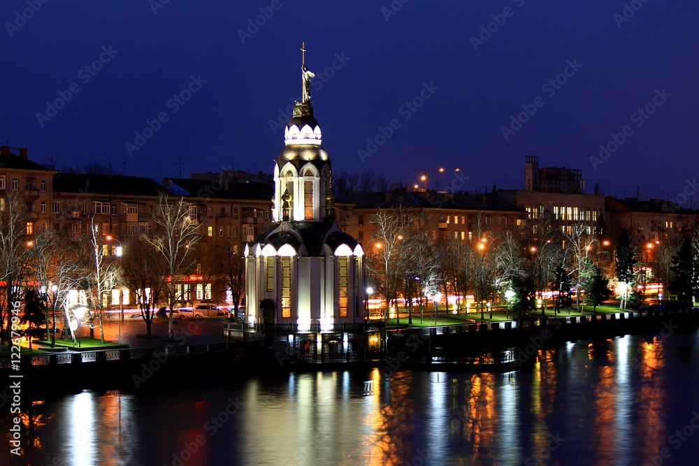 View of the city Dnepr,  Ukraine, beautiful church  with illuminating  at autumn evening.