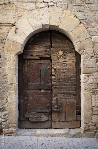 A very old Catalonian door made up of various pieces of wood.