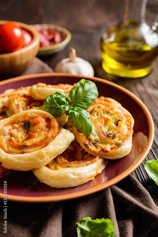 Fototapeta premium Baked puff pastry rolls stuffed with tofu, mozzarella, tomato sauce, garlic and basil