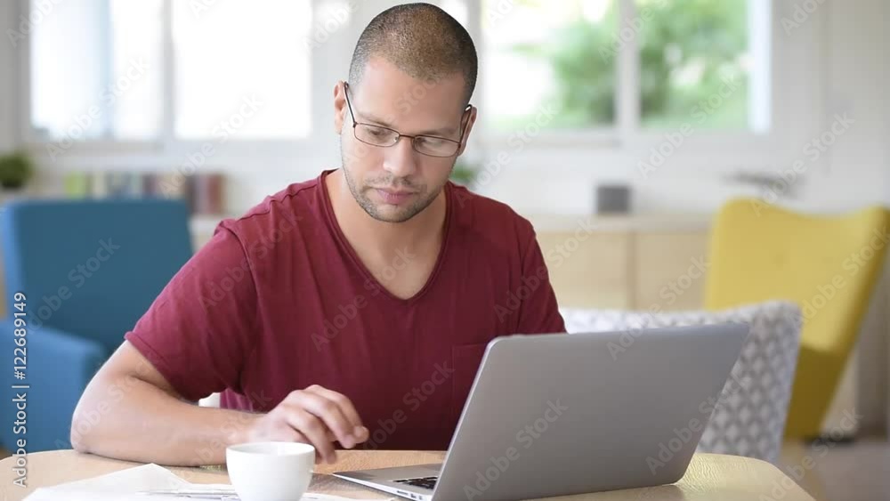 Man at home looking at digital news on laptop Man at home looking at digital news on laptop