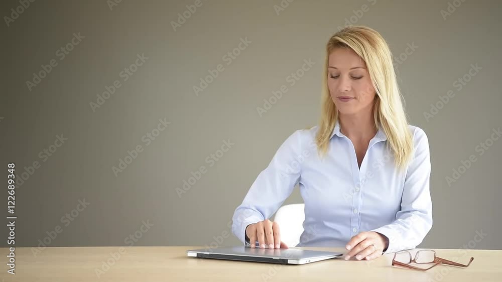 Businesswoman with eyeglasses using laptop, isolated