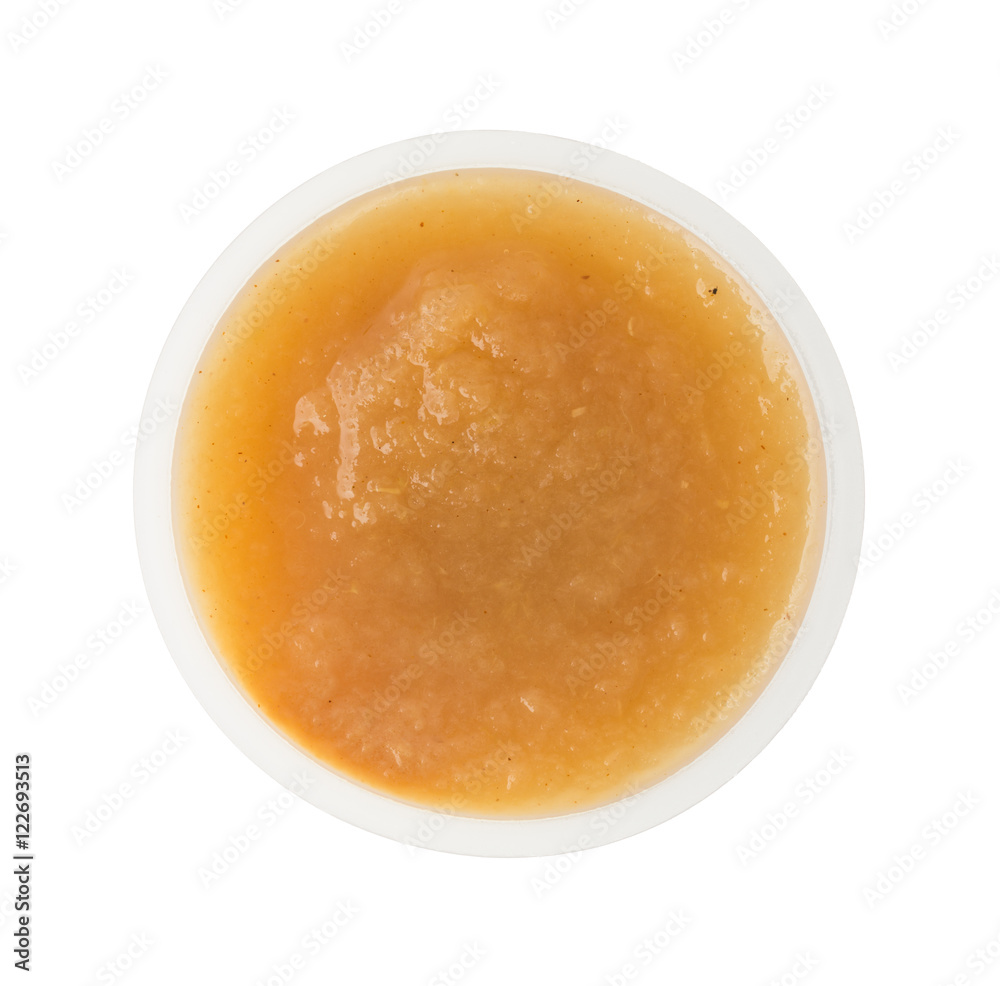 Cinnamon applesauce in a plastic container on a white background