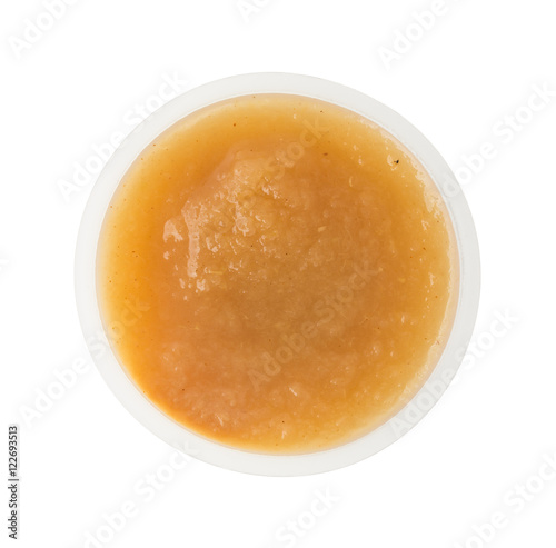 Cinnamon applesauce in a plastic container on a white background