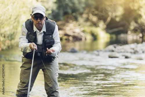 Fly fisherman using flyfishing rod.