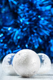 White and silver christmas balls on dark blue bokeh background with space for text. Merry christmas card. Xmas. New Year