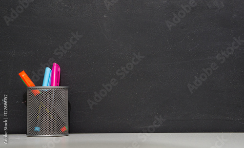 colorful highlighters on a blackboard background