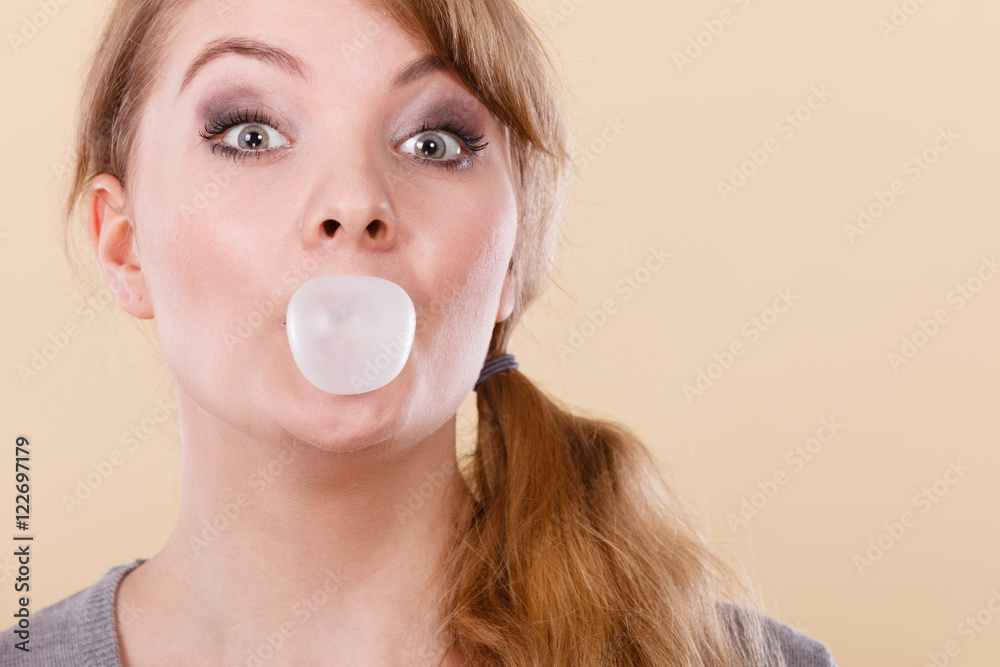 Blonde girl chewing gum making balloon. Blonde girl chewing gum making balloon.