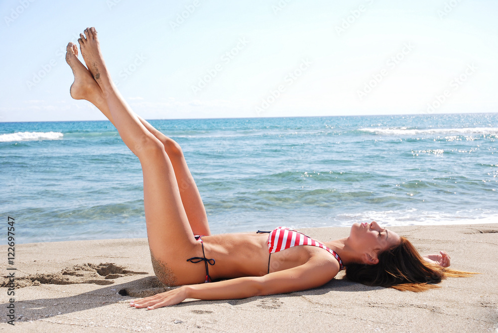 woman perfect body sunbathing by the beach woman perfect body sunbathing by the beach