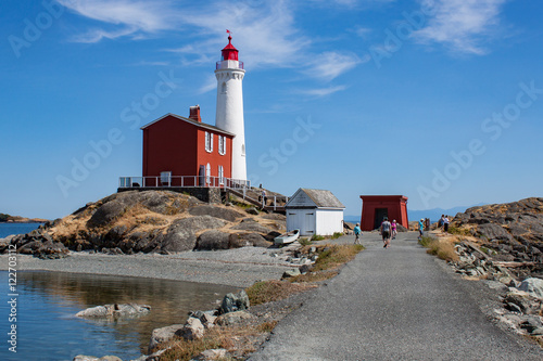 White Lighthouse on Rock Strewn Beach With Path photo