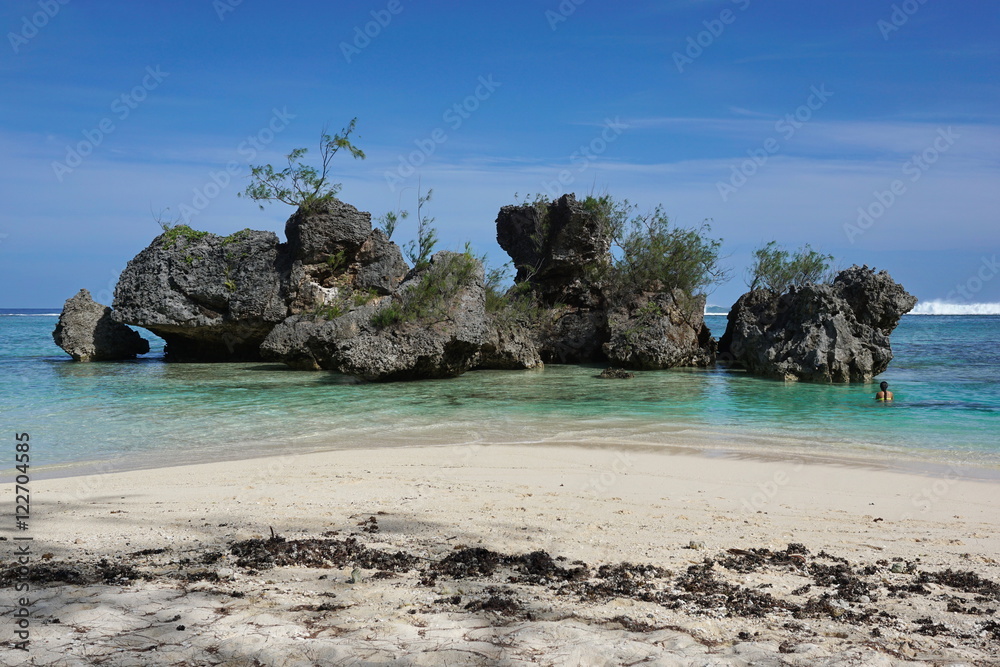 Naklejka premium Large eroded limestone rocks in the lagoon close to sandy beach, Rurutu island, south Pacific ocean, Austral archipelago, French Polynesia