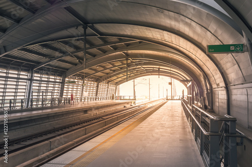 Fototapeta Naklejka Na Ścianę i Meble -  Backlit/backlight shot of train station in morning/evening with bright sun light ray, color filter