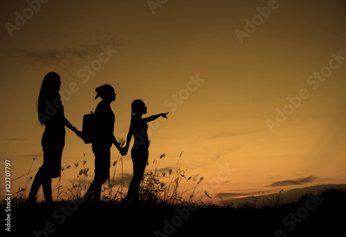 Friends holding hands at sunset.