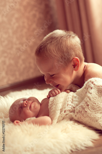 White European boy 5 years communicates with her newborn brother