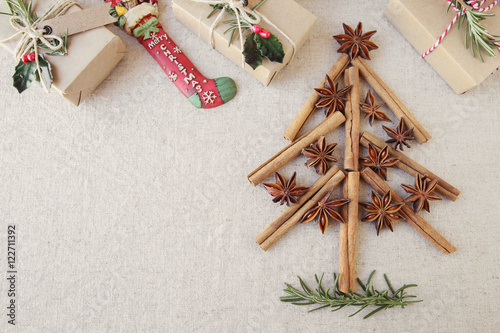 Fototapeta Naklejka Na Ścianę i Meble -  Christmas tree made from anise star seeds and cinnamon sticks with eco present boxes, copy space toning background
