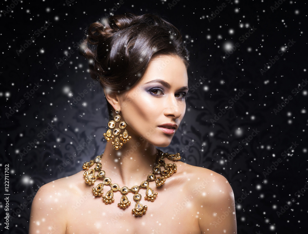 Portrait of a young woman in jewelry on the snow