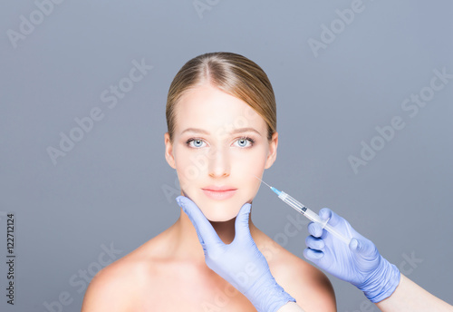 Doctor injecting botox into face of a young woman