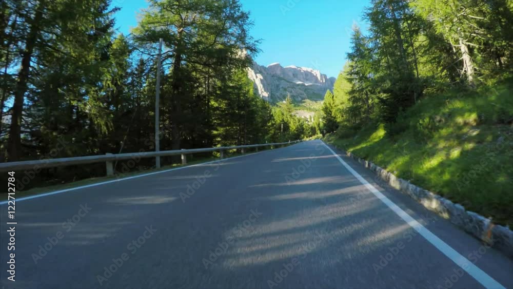 Driving on the Pordoi Pass in the Alps, winding alpine road with spectacular views of the Dolomites mountains. Driving on the Pordoi Pass in the Alps, winding alpine road with spectacular views of the Dolomites mountains.