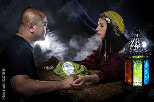 Psychic or fortune teller gypsy with a client doing a seance telepathic ritual photo