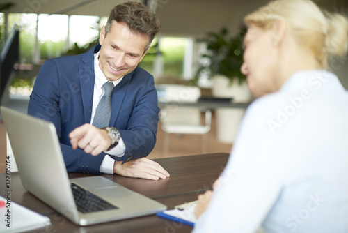 Successful business consultation. Portrait of investment advisor businesswoman sitting at office in front of laptop and consulting with executive professional business man