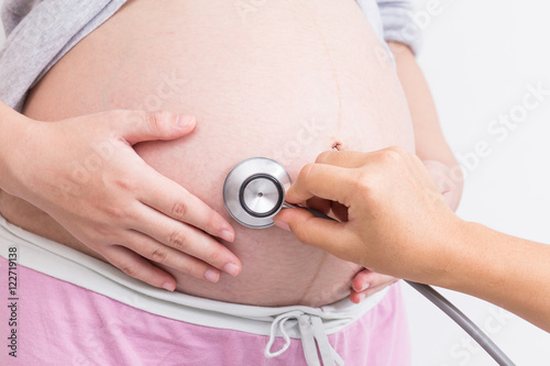 Doctor use stethoscope to hear belly of pregnant woman