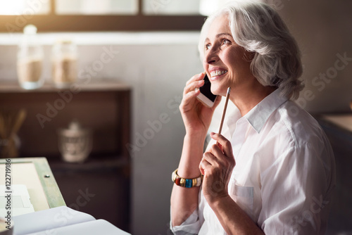 Elderly smiling woman talking on the phone