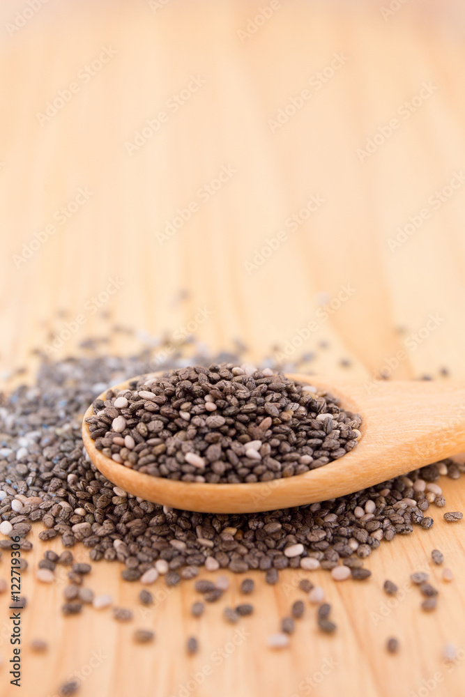 Close up of Chia seeds in a wooden spoon on the table Close up of Chia seeds in a wooden spoon on the table