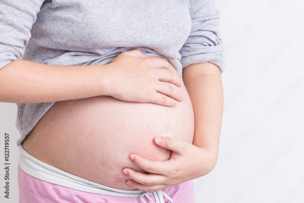 Pregnant woman scratching her belly Pregnant woman scratching her belly