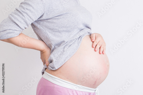 Pregnant woman has backache and touching her torso