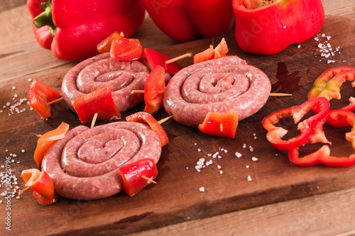 Raw sausage on wooden table.  photo