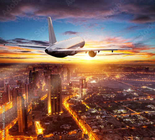 Photography Commercial airplane flying over Dubai city