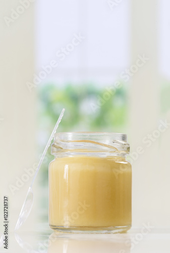 raw organic royal jelly in a small bottle with spoon