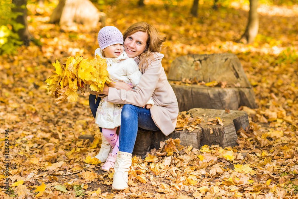 Mother and baby playing in autumn park Mother and baby playing in autumn park